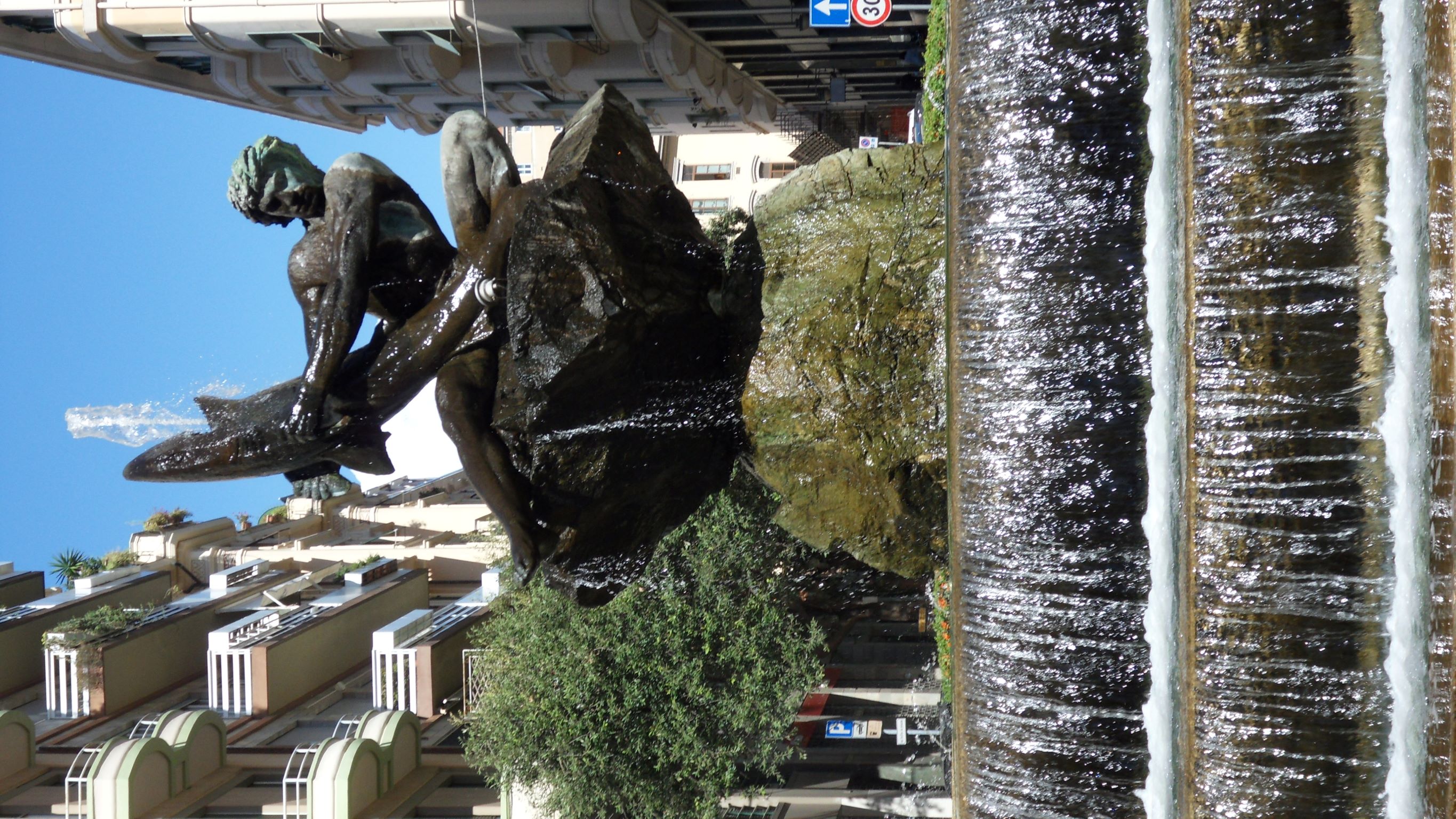 Pasquale Gabbaria Mistrangelo, “L’uomo e lo squalo” di Renata Cuneo (bronzo, 1963) chiamata dai Savonesi “Fontana del pesce”, in piazza Guglielmo Marconi a Savona, 2021 (dopo il restauro durato tre anni completato a gennaio 2021), fotografia digitale.