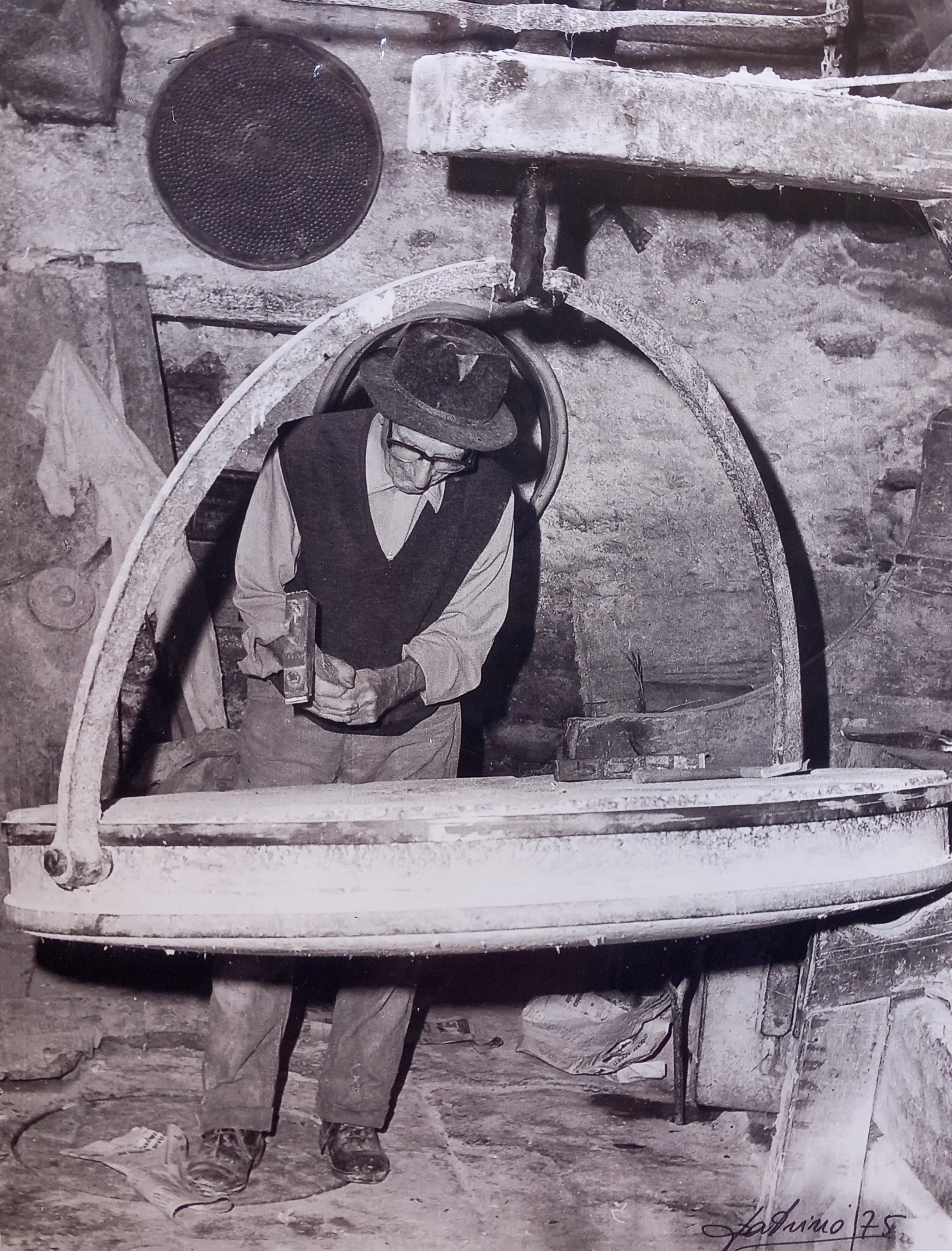 Autore sconosciuto, mugnaio batte la macina per rifinire le scanalature, anni '80, fotografia analogica, 10x15 cm